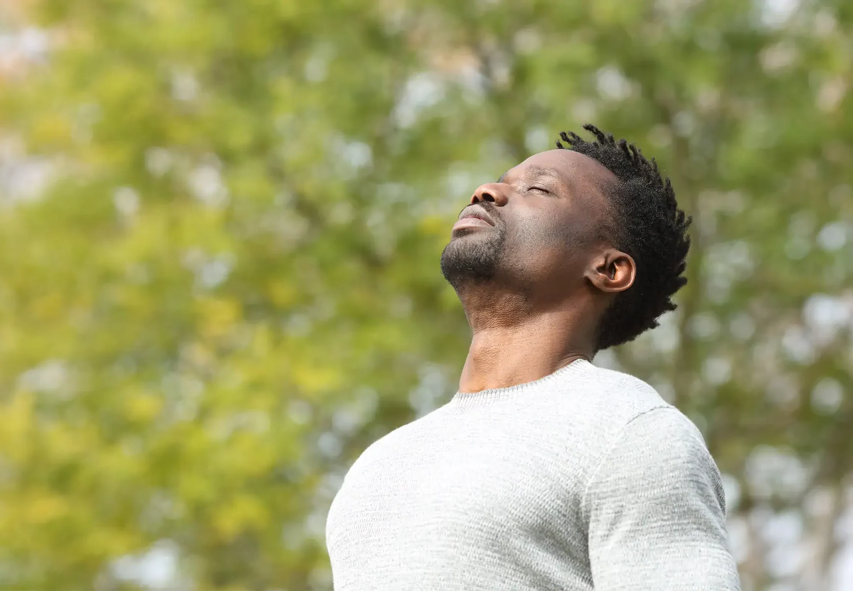 Black man breathing in fresh air in park