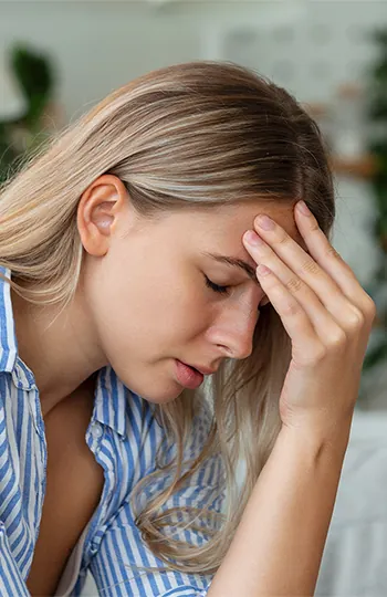 Woman holding head with sinus ache