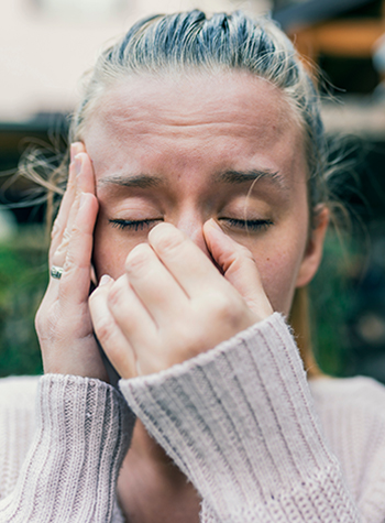 Woman holding her nose with sinus ache