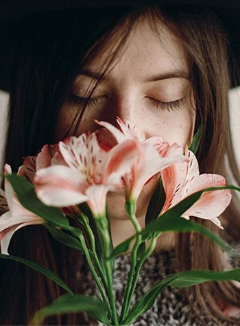 Portrait of woman sniffing pink flowers