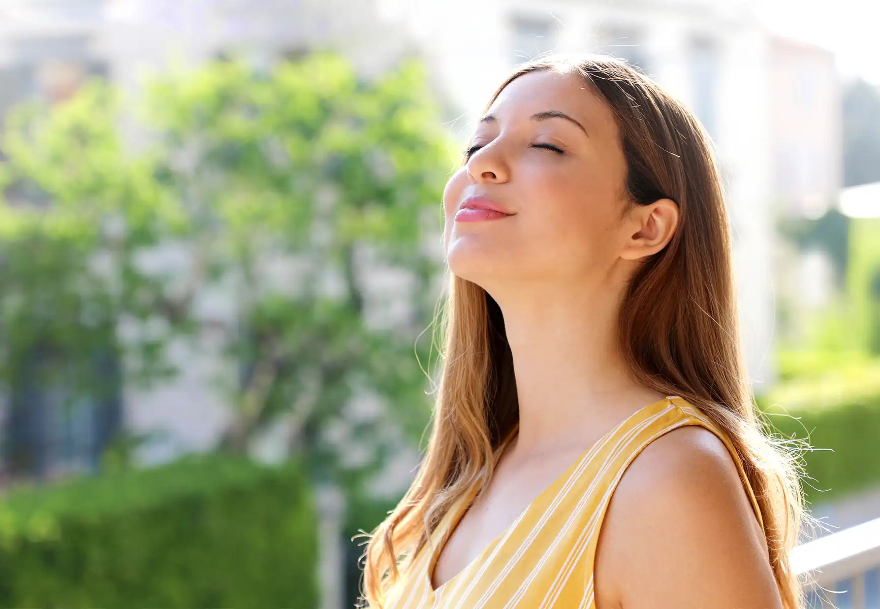 Relaxed woman on balcony breathing in