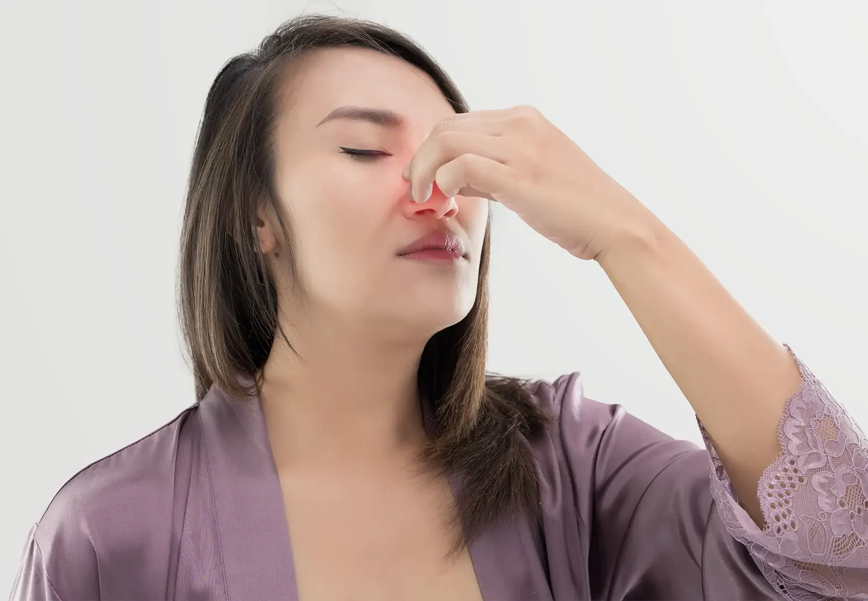 Woman with nasal obstruction holding her nose