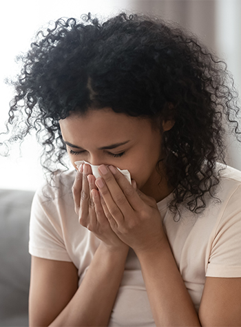 Woman blowing nose in tissue