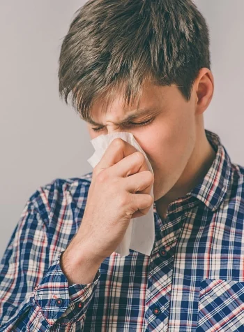 Stressed man blowing his nose