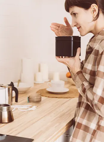 woman sniffing coffee from can and smelling aroma