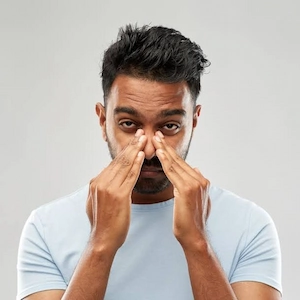 Man holding his congested nose