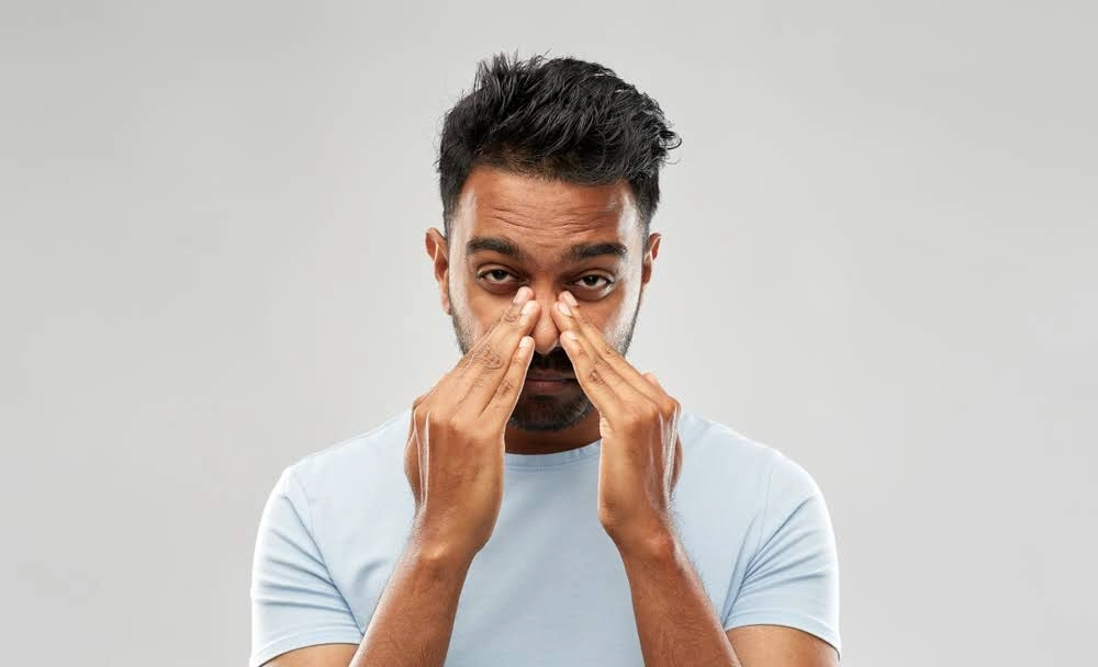 Man holding his congested nose